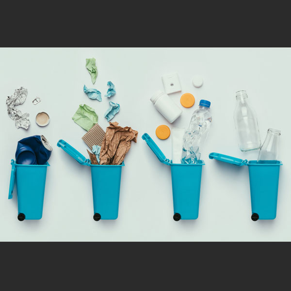 Four dustbins collecting various types of garbage such as glass, metal, and plastic