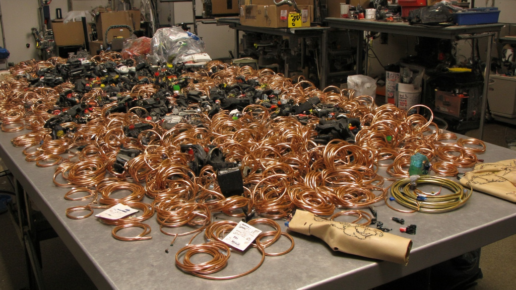 Copper Recycling Materials Assorted copper items including wires, pipes, and electronic components on sorting table in recycling facility