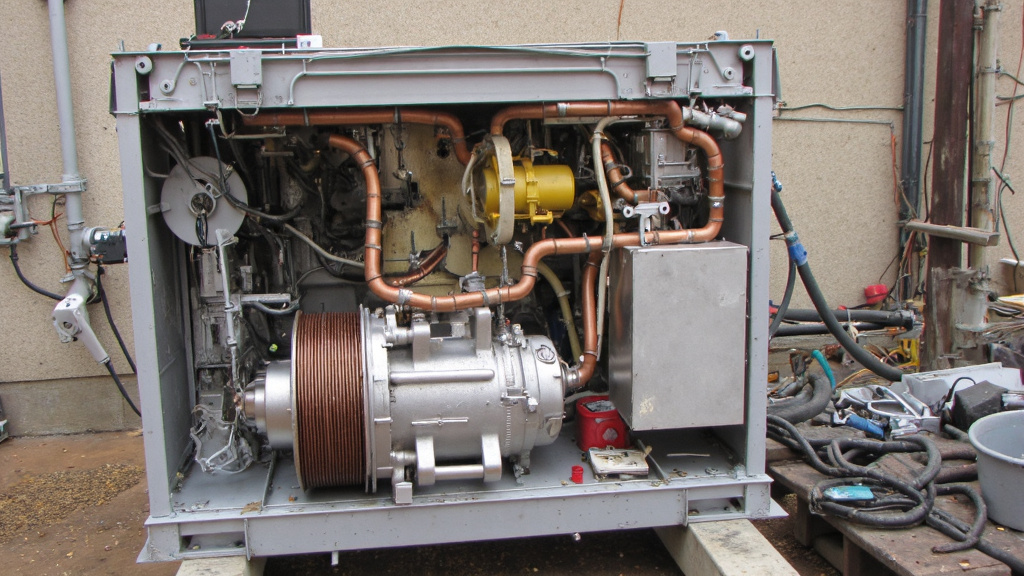 Disassembled Air Conditioning Unit Disassembled air conditioning unit with labeled parts including copper coils, aluminum fins, and compressor on a workbench