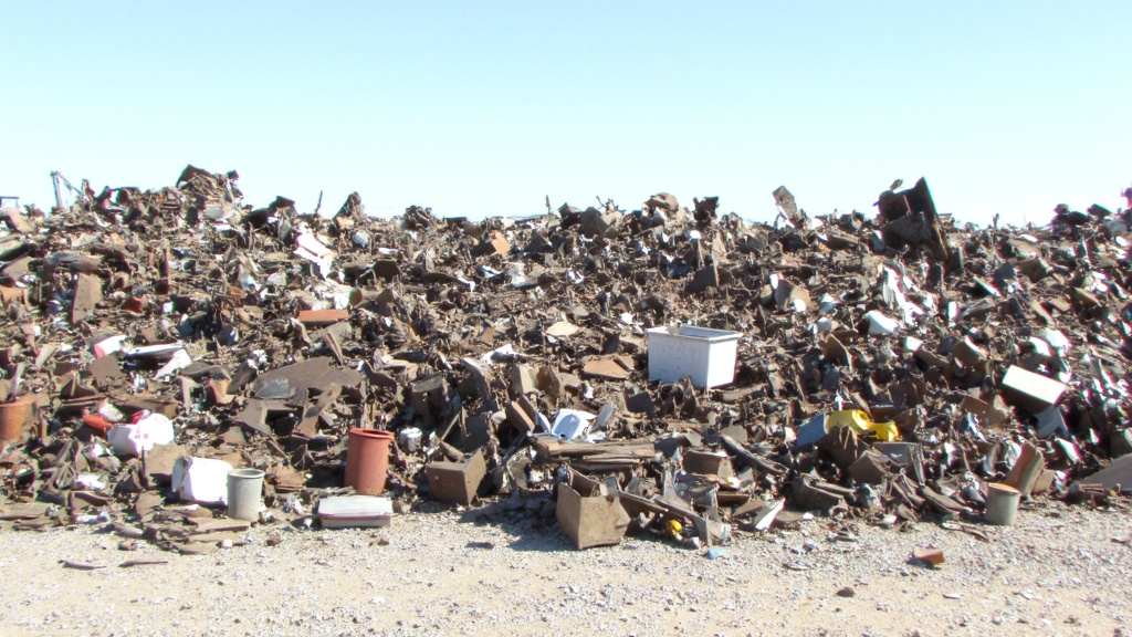 Industrial Scrap Metal Containers Various industrial metal containers filled with assorted scrap metal pieces in a recycling yard.