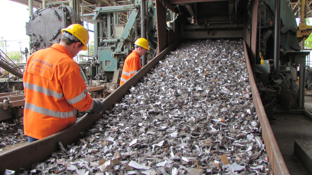 Modern Recycling Facility Processing Scrap Metal Modern recycling facility processing scrap metal with conveyor belts and workers in safety gear.