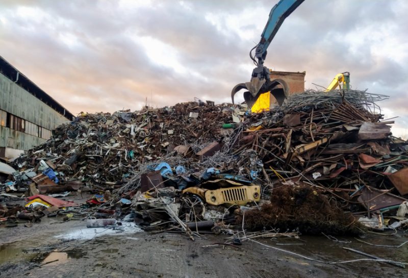 Hydraulic crane collecting scrap metal in Dallas, TX